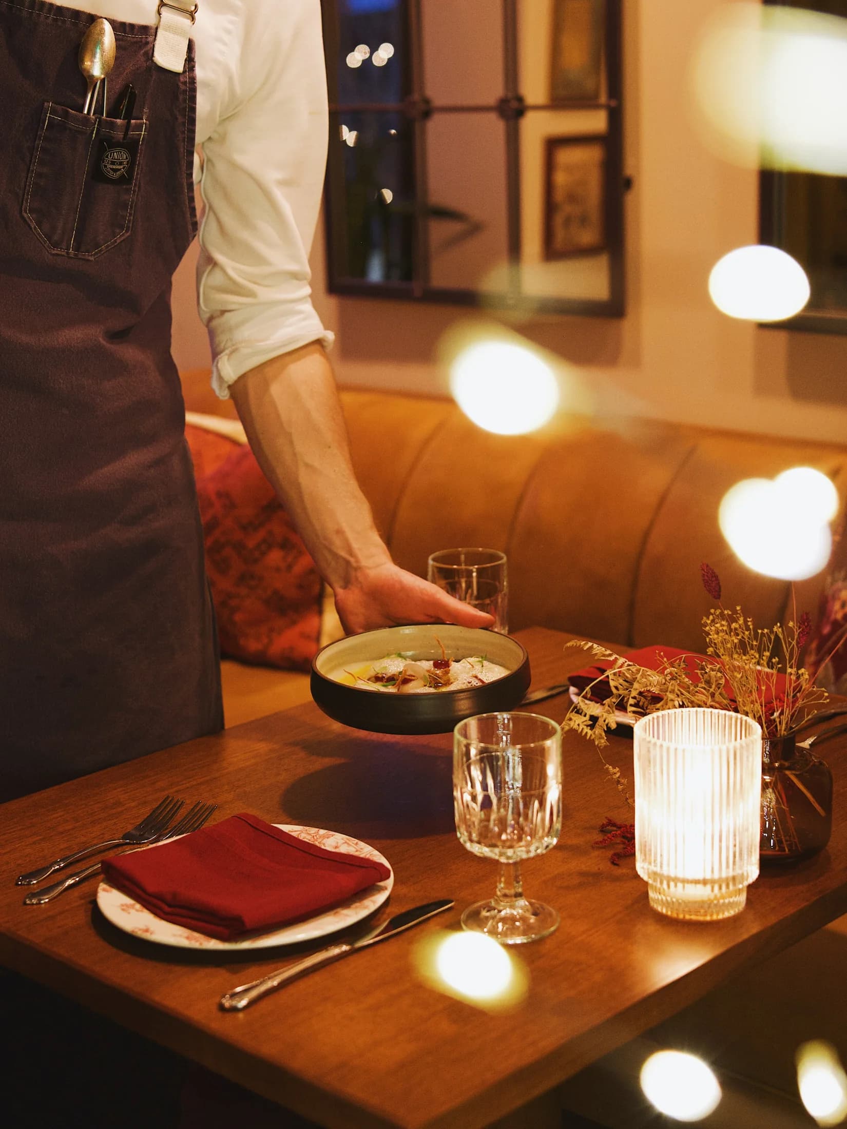 Tableside service at Wildflower, with a dish being set on the table.